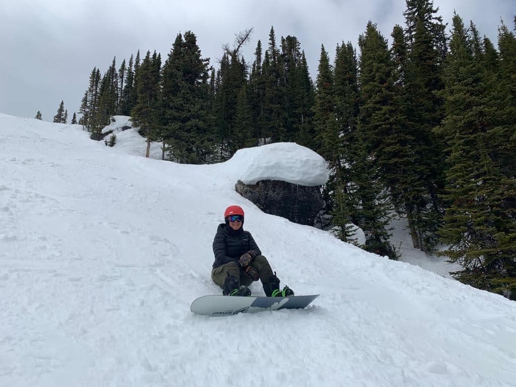 Myle descansando con su snowboard en la nieve