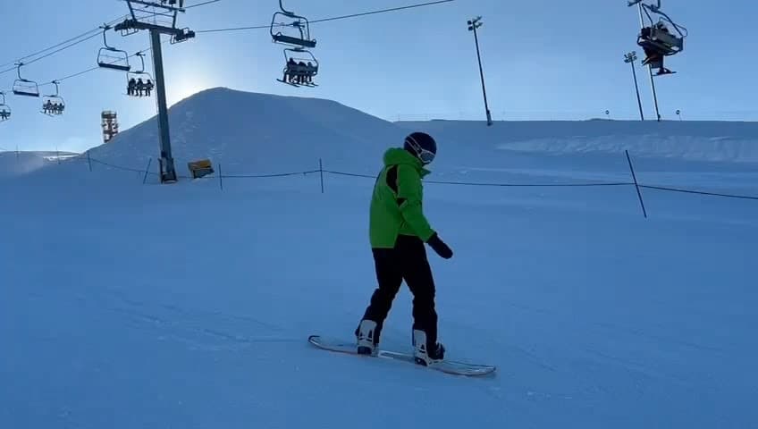 Sebastián practicando snowboard junto a su instructor